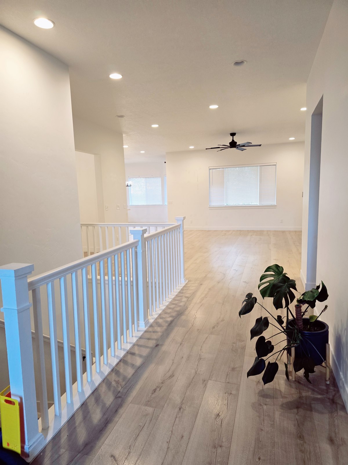 Clean hallway with white railing and polished wood floors