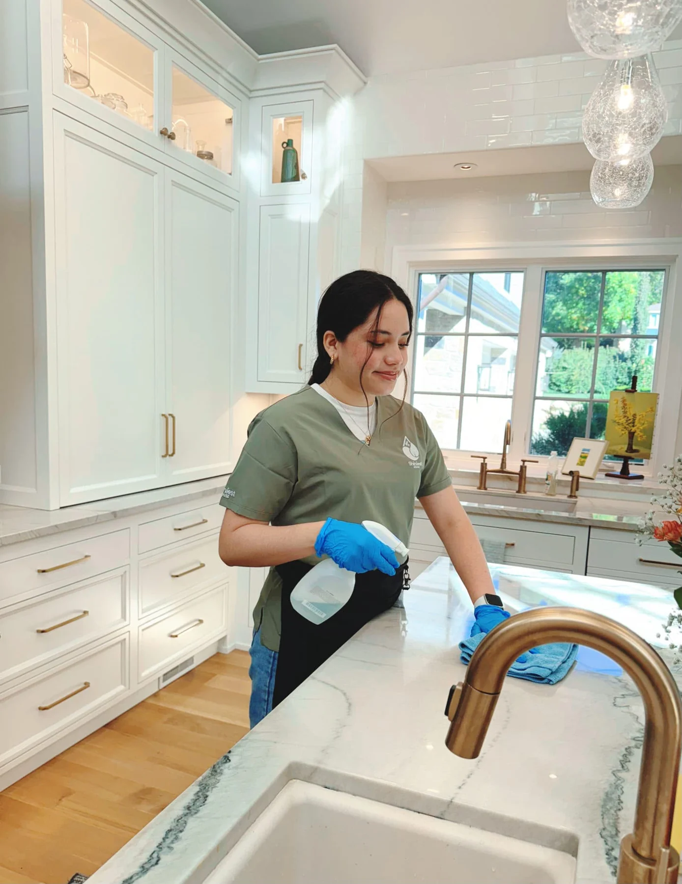 Shiniest House team member cleaning a kitchen countertop
